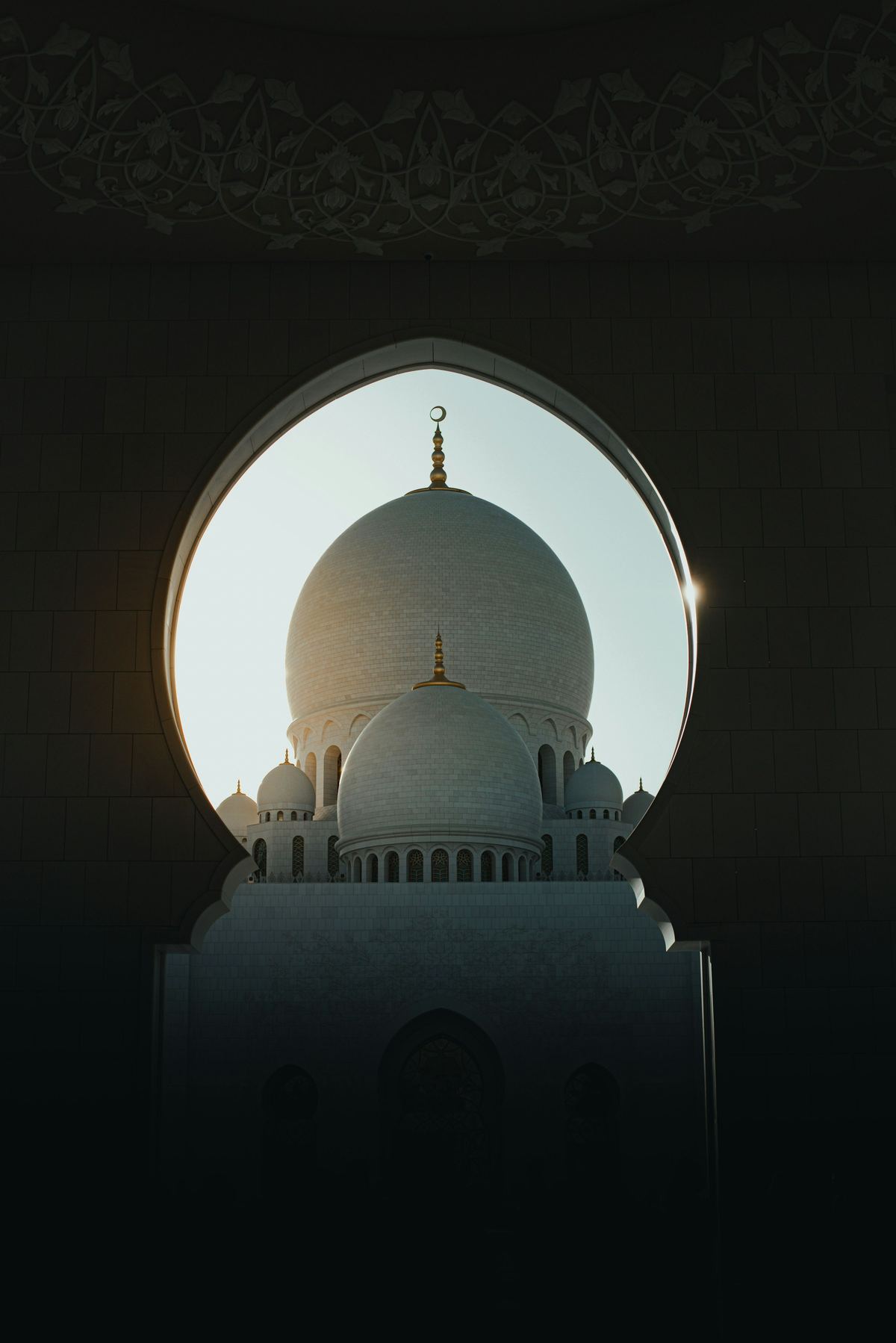 A white dome framed by a dark carved archway