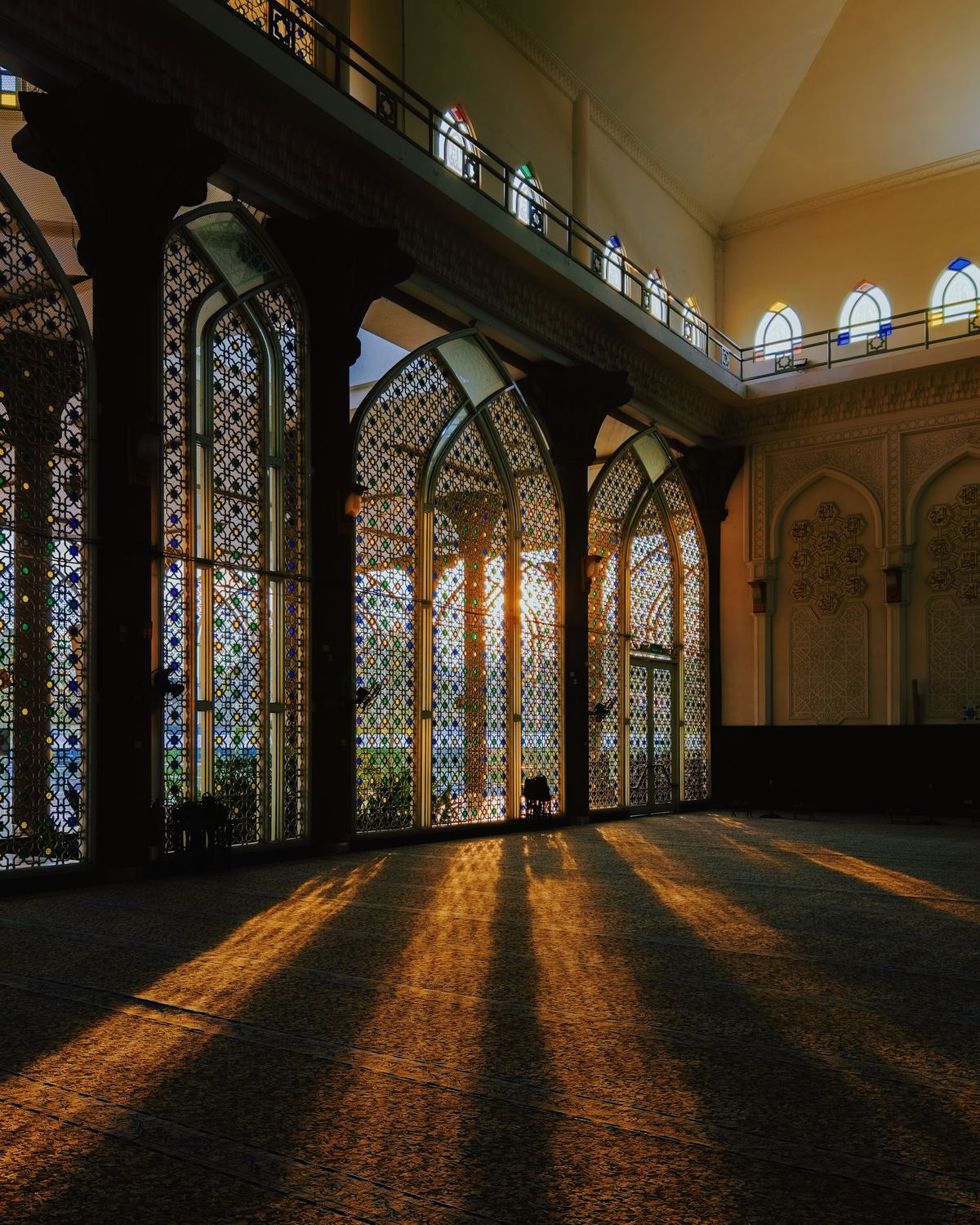 Afternoon light through lattice windows across an empty prayer hall